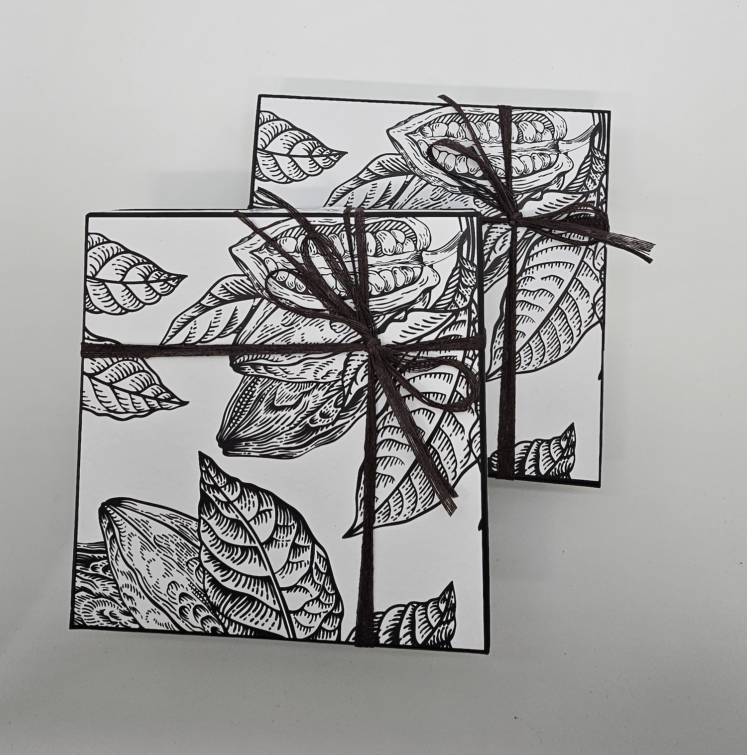 Boîte assortie de chocolats artisanaux Abuela Ili avec couvercle illustré et ruban.