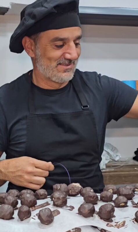 The owner of Abuela Ili Chocolates showing a bar of artisanal chocolate in the factory, added value of the brand.